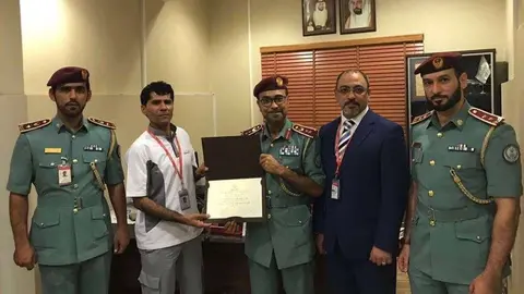 El empleado, segundo por la izquierda, fue condecorado con un diploma.