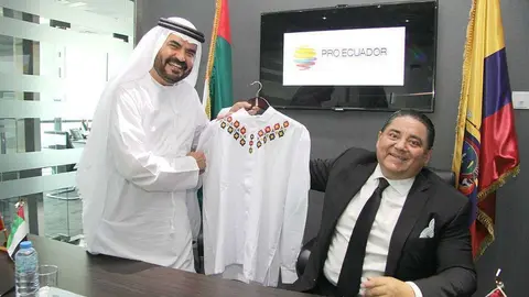 Mario Vallejo entrega al vicepresidente de DP World tras la firma del acuerdo en la oficina de ProEcuador en Dubai una camisa bordada tradicional ecuatoriana. (EL CORREO)