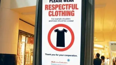 Cartel indicador del Código de Vestimenta en centros comerciales de EAU.