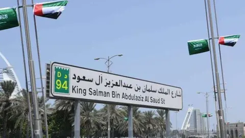 La calle King Salman Bin Abdul Aziz engalanada con baderas saudíes y emiratíes en Dubai.