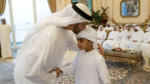 El príncipe heredero de Abu Dhabi junto a uno de los hijos de los héroes caídos.