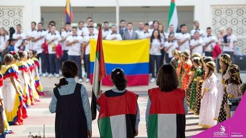 La delegación colombiana y estudiantes emiratíes escuchan los himnos de sus países en un solemne acto. (WorldSkills Abu Dhabi) 