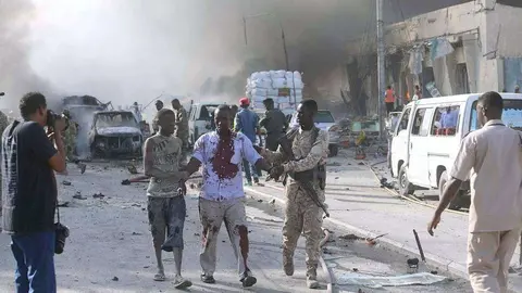 Herido camina ayudado por la calle tras el atentado en Mogadiscio.