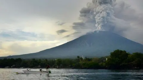 En la imagen de AFP, el Monte Agung lanza cenizas y humo.