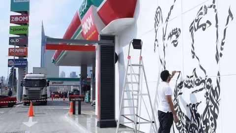 El artista Diaa Allem pintando el mural dedicado a Sheikh Zayed en una estación de servicio de ENOC. (WAM)