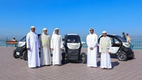Responsables de la Municipalidad de Ajman con los nuevos vehículos híbridos. (WAM)