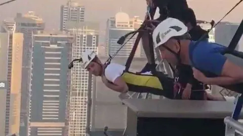 El entrenador blanco subido a la tirolina de Dubai Marina.
