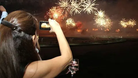 Residentes graban con sus celulares el espectáculo de fuegos artificiales en Ras Al Khaimah. (EL CORREO)