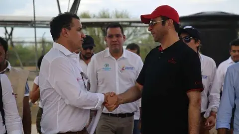 A la izquierda, el representante de la Media Luna Roja de EAU saluda a un funcionario colombiano.