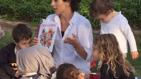 La organizadora de La Hora del Cuento de Dubai, rodeada de pequeños. 