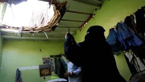 En la imagen de Reuters, una saudí fotografía los desperfectos en una vivienda de los restos del misil lanzado contra Riad.