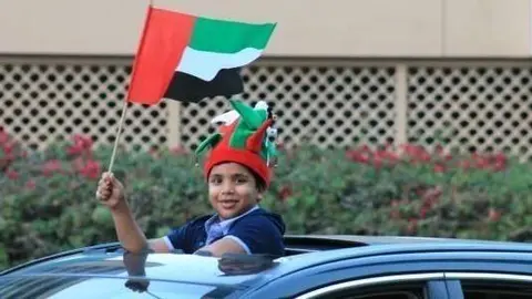 Un niño enarbola una bandera de Emiratos Árabes en el Día Nacional de 2012. (Celia HK)