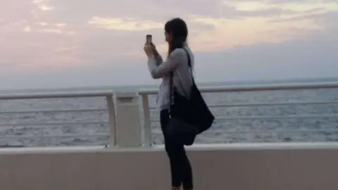 Una joven toma una foto en La Palmera de Dubai. (EL CORREO)
