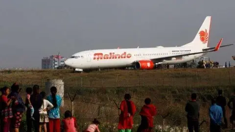 Niños observan al avión malasio en el aeropuerto.