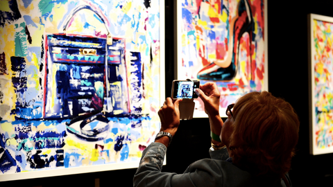 Una de las asistentes fotografía los cuadros de Paloma Redecilla. (Manaf K. Abbas)