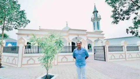 Saji Cheriyan delante de la mezquita que ha construido para los trabajadores.