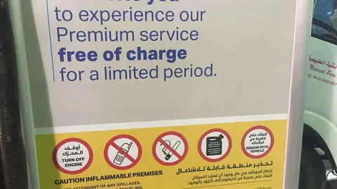 Cartel anuncia el comienzo del 'autoservicio' en las gasolineras Adnoc. (EC)