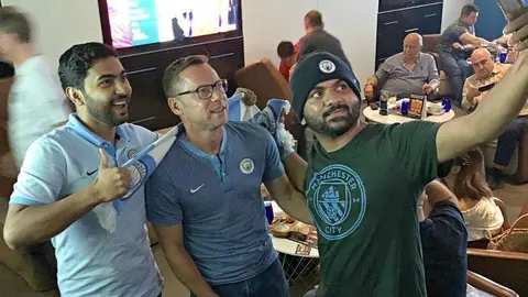 Paul Dickov se hace un selfie junto a dos aficionados en el hotel Southern Sun de Abu Dhabi. (Cedida)