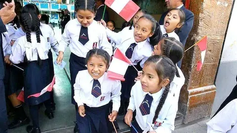 Escolares peruanos celebran con banderas las fiestas patrias de su país. (Cedida)