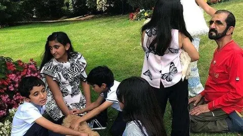 El gobernante de Dubai junto a sus nietos y unos cachorros.