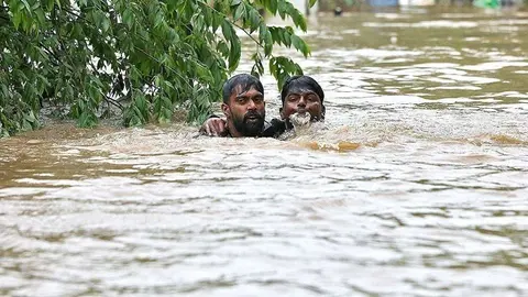 En la imagen de Reuters, dos jóvenes indios literalmente con el agua al cuello.
