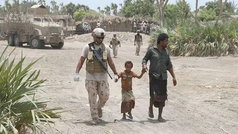 Militares de la Coalición Árabe atienden a niños tras el bombardeo de las milicias hutíes. (WAM)
