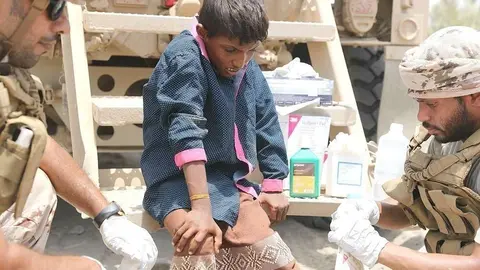 Militares de la Coalición Árabe atienden a niños tras el bombardeo de las milicias hutíes. (WAM)