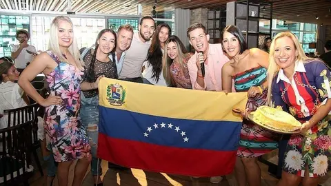 Grupo de asistentes junto a la bandera de Venezuela. (ELCORREO)