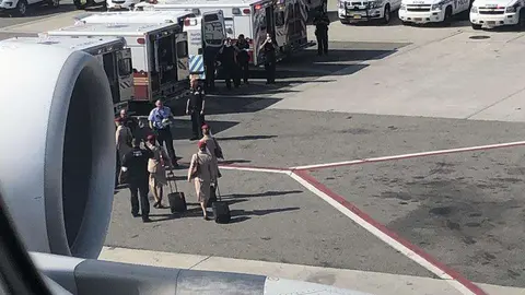 Tripulantes de cabina de Emirates se dirigen a las ambulancias en el aeropuerto de Nueva York.