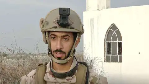 Soldado emiratí explica ante la mezquita profanada las acciones de los hutíes en Yemen. (WAM)