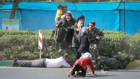 Asistentes al desfile militar en el sur de Irán intentan esquivar la lluvia de balas. (MEHR NEWS AGENCY / MEHDI PEDRAMKHOO)