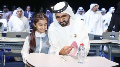 El jeque Mohamed bin Rashid Al Maktoum habla con una niña durante la presentación en Dubai de la plataforma 'Madrasa'. (WAM)