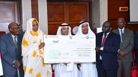 Entrega de uno de los cheques de la Media Luna Roja para los huérfanos de Sudán. (WAM)