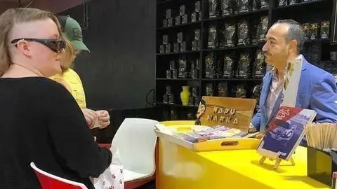 Ernesto Roca da a conocer los chocolates ecuatorianos a un visitante. (Cedida)