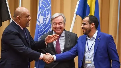 El ministro de Relaciones Exteriores de Yemen, a la izquierda, le da la mano al negociador de los hutíes ante el secretario general de las Naciones Unidas, Antonio Guterres. (AFP)