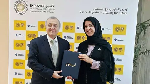 El embajador de Uruguay, Nelson Chabén, entrega a la ministra de Estado de Cooperación Internacional de Emiratos Árabes, Reem Al Hashima, el documento de participación de su país en la Expo 2020 de Dubai. (EL CORREO)