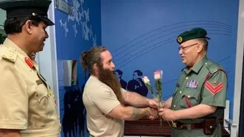 La Policía de Dubai publicó esta imagen en Instagram del turista con la rosa.