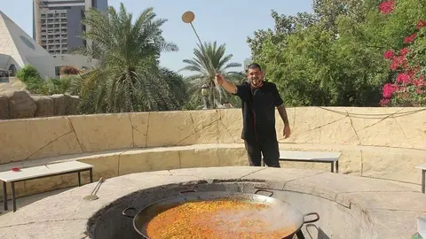 El chef del Seville's, Aleix Font, junto a la enorme paella que el restaurante preparó para la ocasión. (EL CORREO)