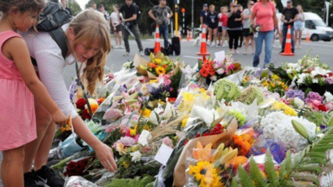 Niñas dejan flores en el lugar del atentado.