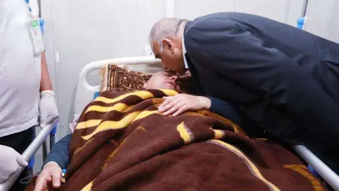 El primer ministro iraquí, Adel Abdul Mahdi, besa a uno de los supervivientes del accidente de Irak.