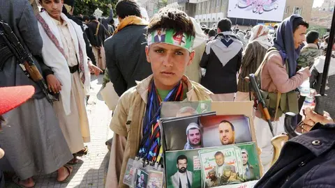 Un niño muestra fotos de los líderes hutíes en Saná, capital de Yemen. (EPA)