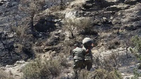  En la imagen de Reuters, personal militar traslada escombros del misil.