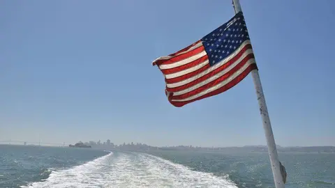 Barco con bandera estadounidense surca el mar. (pxhere.com)