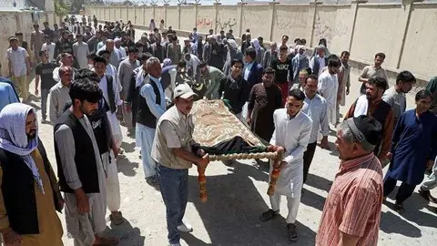 En la imagen de AFP, familiares portan los restos de una de las víctimas tras el brutal ataque en una boda. 