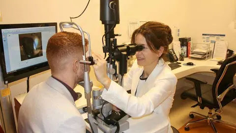 La oftalmóloga española Luisa Sastre atiende en su consulta de Moorfields en Dubai a un paciente. (EL CORREO)