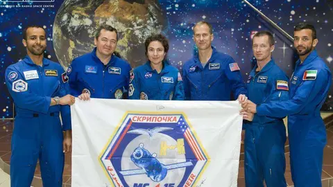 Los dos astronautas emiratíes (primero y último) presentan el logo del programa espacial emiratí. (WAM)