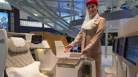 Una azafata muestra el nuevo asiento de la clase Business de Emirates.