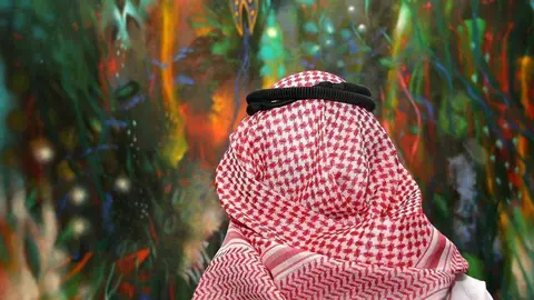 Ciudadano árabe contempla en Dubai la obra 'El jardín de las hadas' de Carlos Jacanamijoy. (R. Pérez)