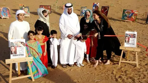 El jeque Sultan bin Ali Al Khateri, de la tribu Khawater, en el momento de inaugurar la exposición junto a la pintora Paola Moscatelli -primera por la derecha-. (EL CORREO)