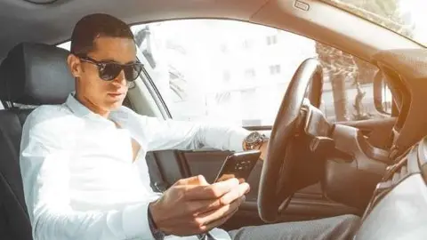Un joven mira su móvil mientras conduce. (Fuente externa)